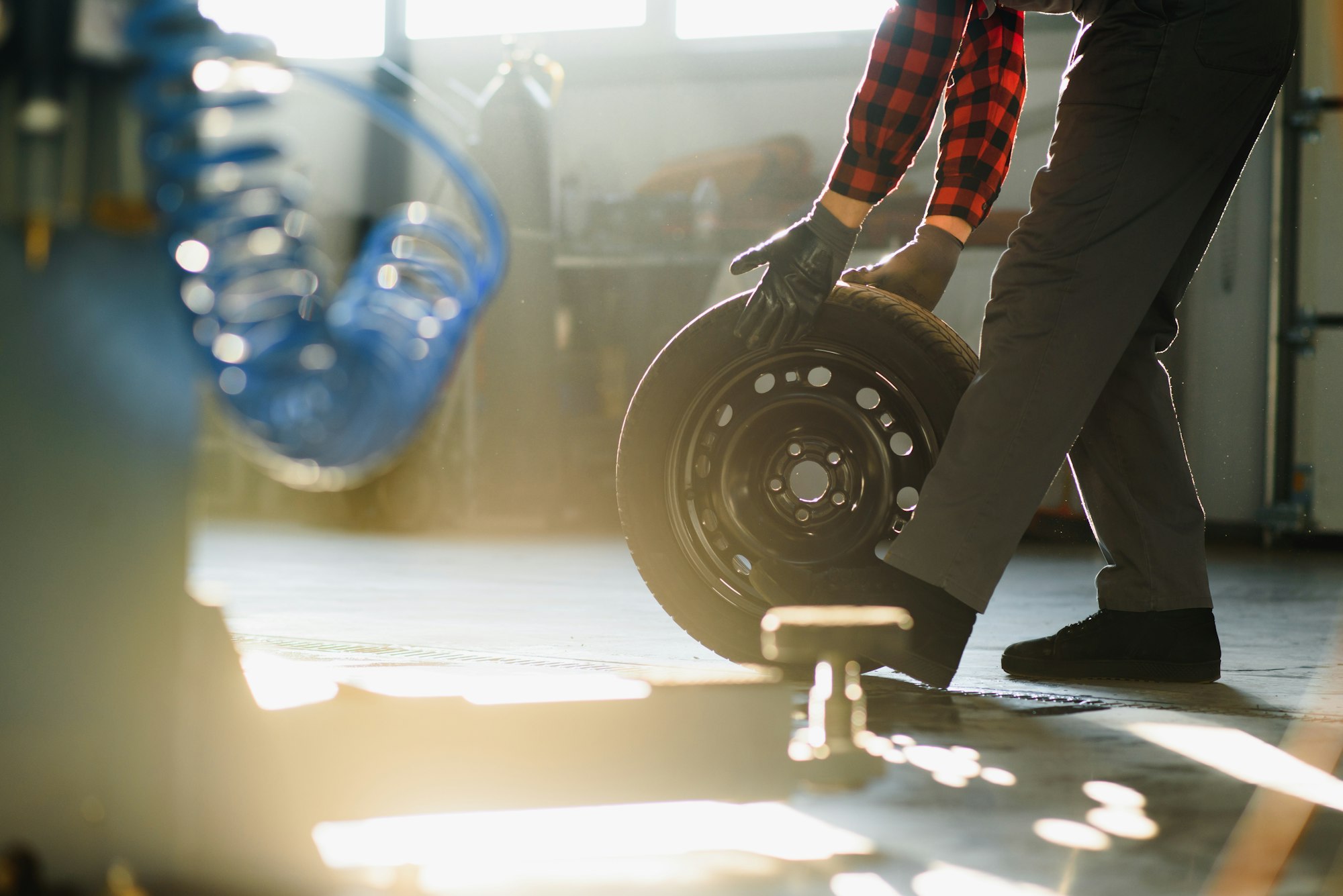 Mechanic holding a tire tire at the repair garage. replacement of winter and summer tires.