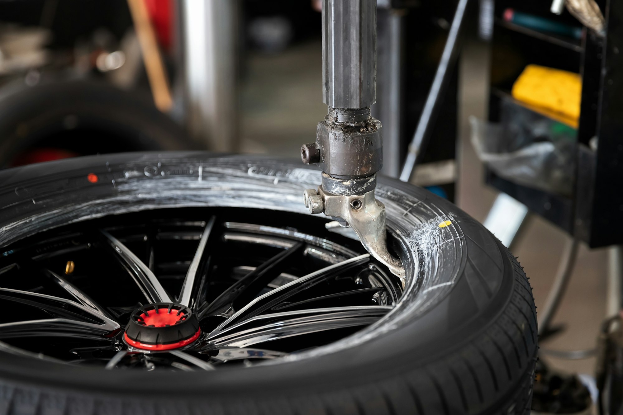 Wheel with tire on tire changing machine in auto repair service.