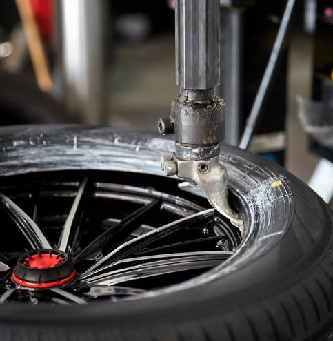 Wheel with tire on tire changing machine in auto repair service.